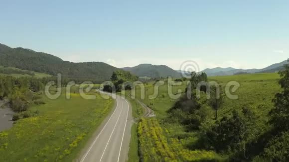 欧洲夏季白天在带有山脉背景的乡村道路上的风景游览视频的预览图