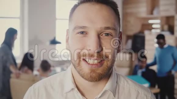 在现代光办公室工作的快乐欧洲商人的特写肖像看着相机摆姿势和微笑4K视频的预览图