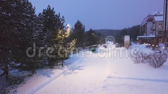 白雪皑皑的小路上有灯笼和散步的人剪辑度假胜地有公园和游客在雪地里漫步视频的预览图