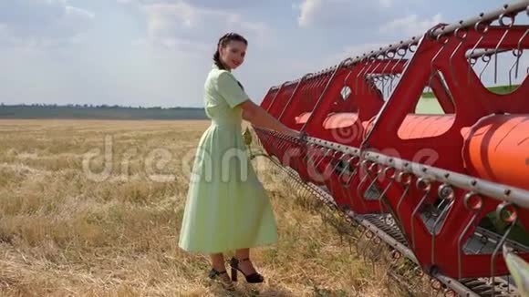 农村妇女在后台农业机械上缓慢地在田间跳舞视频的预览图