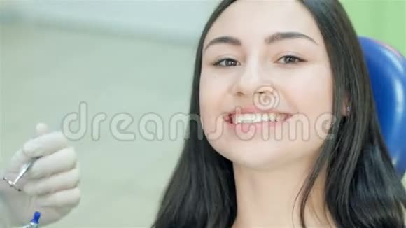一位牙齿微笑的女病人的特写镜头视频的预览图