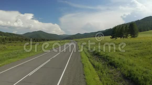 欧洲夏季白天在带有山脉背景的乡村道路上的风景游览视频的预览图