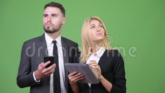 年轻的商业夫妇一起使用数字平板电脑和智能手机视频的预览图
