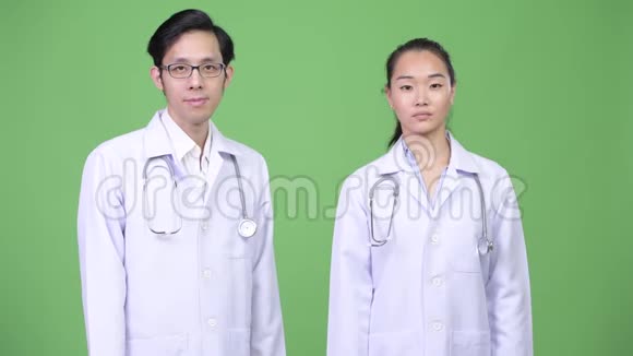 一对年轻的亚洲夫妇的医生举起拳头视频的预览图