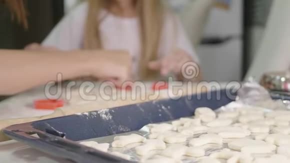 小女孩在厨房帮妈妈做饼干在厨房做不同形状的饼干视频的预览图