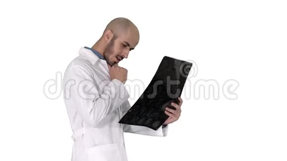 年轻的男性医生在白色背景下行走时阅读和复习MRI脑扫描视频的预览图