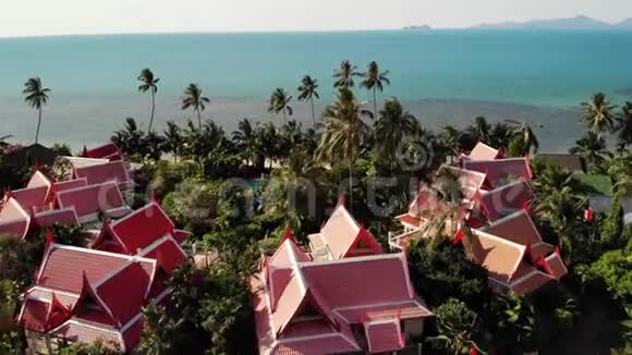海滨的东方民居美丽的东方小屋和绿色椰子棕榈树坐落在平静的海上视频的预览图