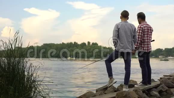 父子一起钓鱼在湖边放松最喜欢的爱好视频的预览图