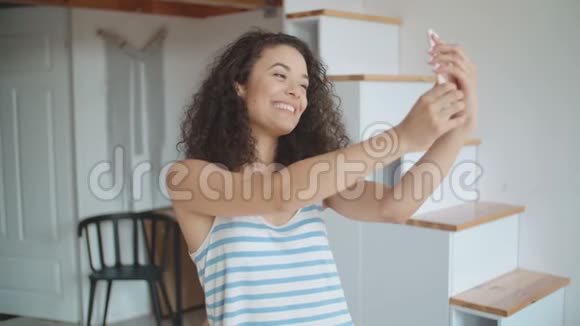 年轻女子在厨房用手机自拍视频的预览图