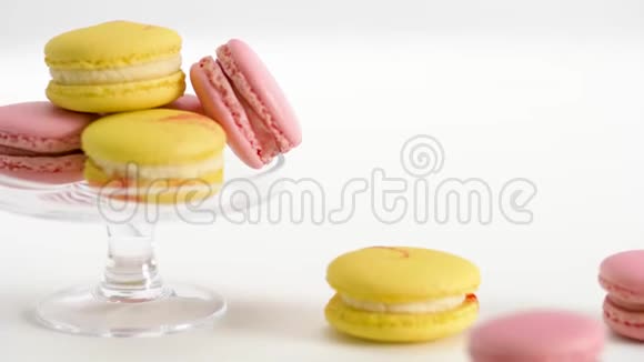 玻璃展台和桌子上有黄色和粉红色的马卡龙视频的预览图