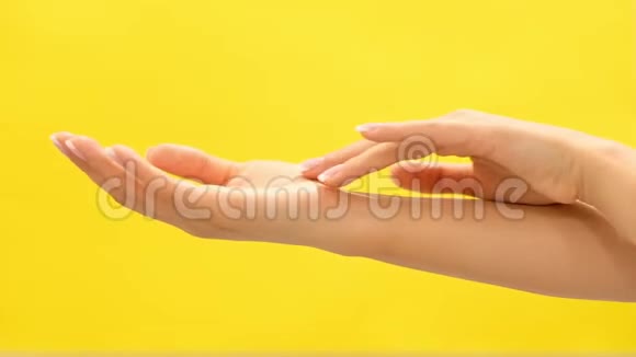 清洁修剪良好的年轻女性的手皮肤护理浅黄色背景在白色背景下按摩视频的预览图