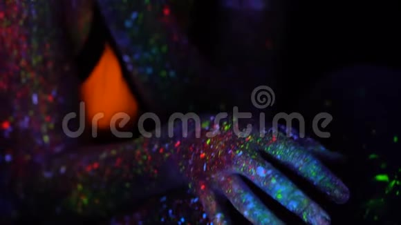 美丽的女人与紫色头发移动在霓虹灯紫外光滑动有荧光创意的迷幻少女视频的预览图