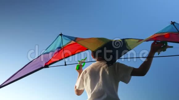 幼儿在蓝天背景上玩风筝梦想飞行的概念视频的预览图