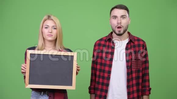 年轻夫妇拿着黑板看上去很震惊视频的预览图