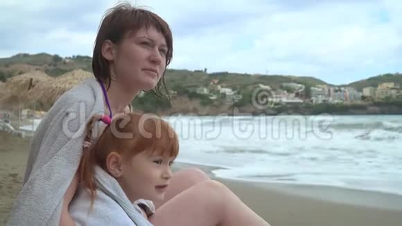 母女俩坐在沙滩上看着大海视频的预览图