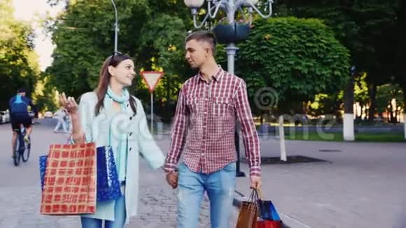 年轻夫妇带着购物袋穿过城市TT视频的预览图