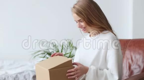 美丽的年轻女子打开盒子里面有包裹视频的预览图