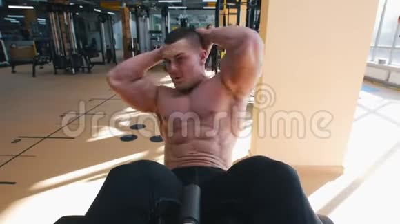 健身者穿着紧身衣赤裸的躯干在健身房的长凳上做着皱褶视频的预览图