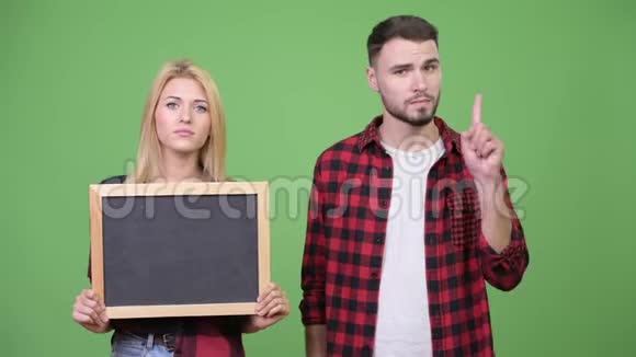 年轻夫妇举着黑板手指并举视频的预览图