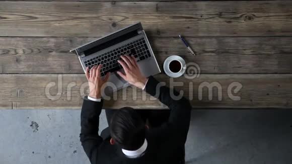 男子在笔记本电脑上打字的俯视图视频的预览图