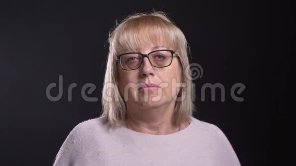 一位戴眼镜的老白种人金发女性正对着镜头近距离拍摄背景与黑色隔离视频的预览图
