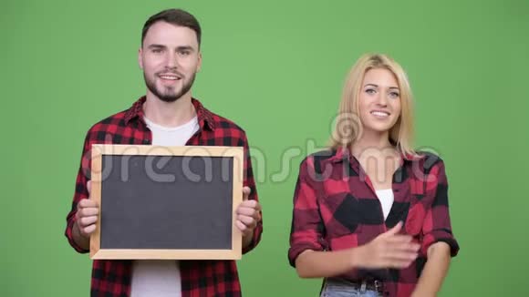 年轻夫妇拿着黑板双臂交叉在一起视频的预览图