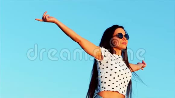 自由美丽快乐微笑欢乐时尚的欧洲可爱少女在美丽的蓝色中举起双手视频的预览图