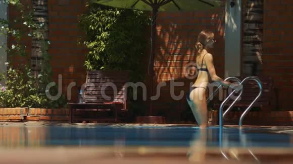 苗条的女人走进泳池手里拿着禁泳器视频的预览图