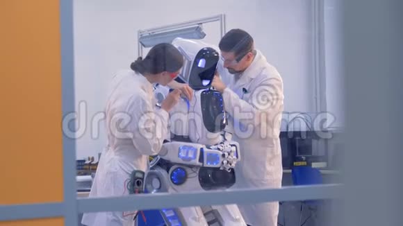 实验室的工作人员正在为一个由一位女工程师用电脑实现的机器人提供指导视频的预览图