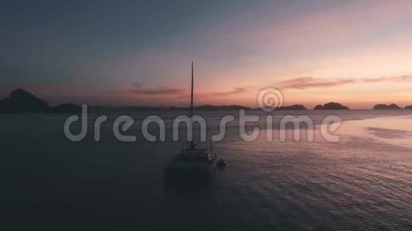 空中无人驾驶飞机观帆船停泊在海湾与清澈和绿松石水在日落帆船游艇视频的预览图