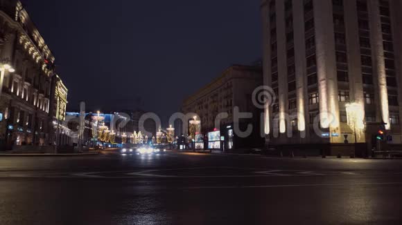 夜城的十字路口雄伟的建筑汽车从左到右行驶视频的预览图