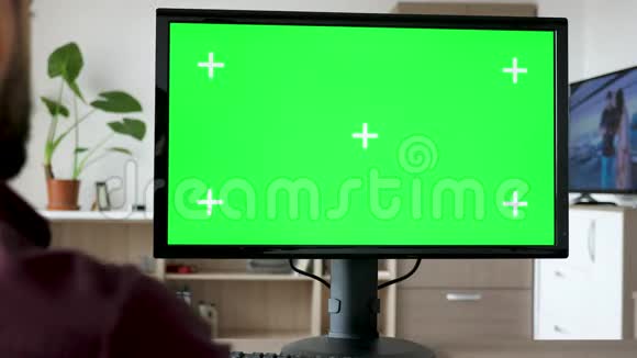 无法辨认的人看着现代的个人电脑用绿色的大屏幕模拟视频的预览图