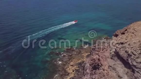 鸟瞰锯齿状的海岸和海滩兰萨罗特西班牙加那利红艇全速航行视频的预览图