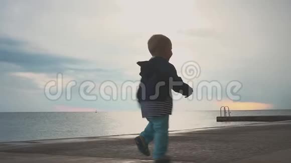 快乐的孩子在海边玩得开心孩子在海边玩在海边奔跑的男孩和孩子一起度假水上娱乐视频的预览图