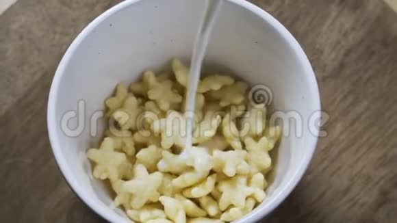 一个女人用星号把牛奶倒在玉米片上概念健康早餐适当营养饮食体重视频的预览图