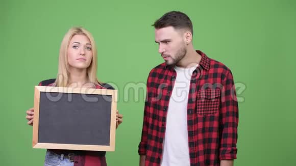 年轻夫妇拿着黑板看上去很震惊视频的预览图