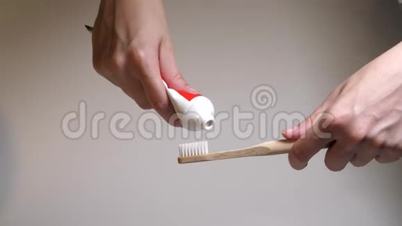 把牙膏从试管里挤到木制牙刷上带有新鲜白色牙膏的牙刷白色刚毛视频的预览图