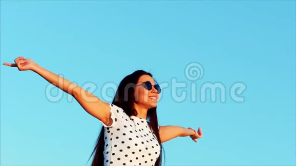 自由美丽快乐微笑欢乐时尚的欧洲可爱少女在美丽的蓝色中举起双手视频的预览图