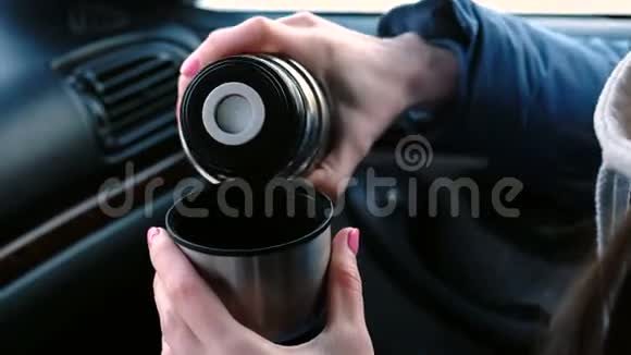 在冬天贴身女人用热水瓶在杯子里倒了一杯热茶视频的预览图