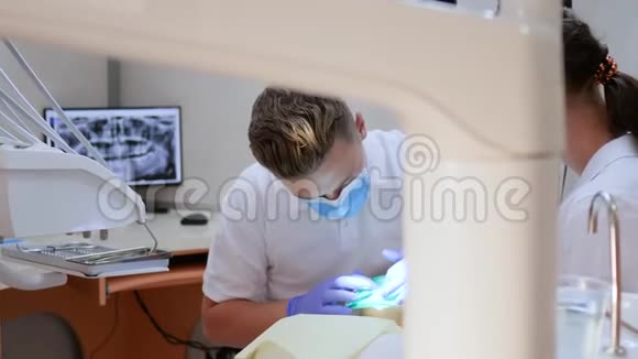 医生戴着医用手套在牙科医生办公室工作配备了现代化的仪器视频的预览图
