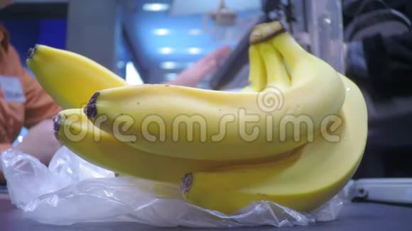 香蕉在超市里买手在一堆香蕉的背景下给收银员钱视频的预览图