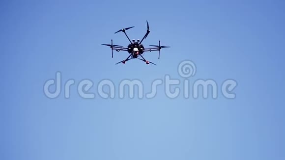 黑色无人机在蓝天上飞行旋转叶片底部视野剪辑小型四翼飞机由视频的预览图
