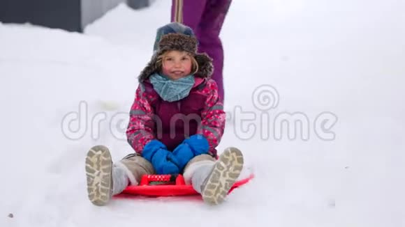 一家人在冬天的公园里散步有孩子的父母在雪橇上视频的预览图