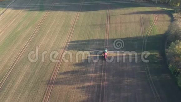 拖拉机在秋天的麦田里喷洒树影空中视频的预览图