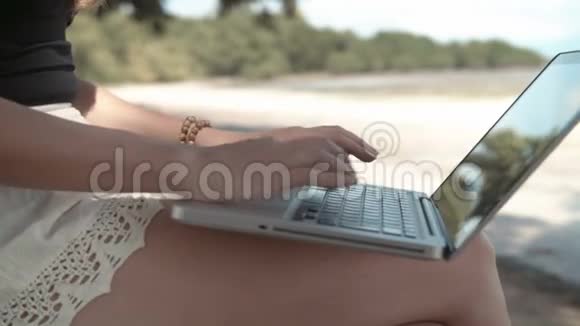 在户外一台笔记本电脑上女人的手在打字视频的预览图