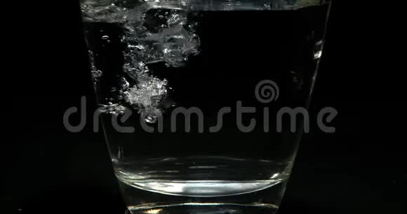在黑色背景下倒入玻璃中的水视频的预览图