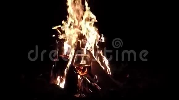 一杯酒中的火影晚上的篝火慢动作背景视频的预览图