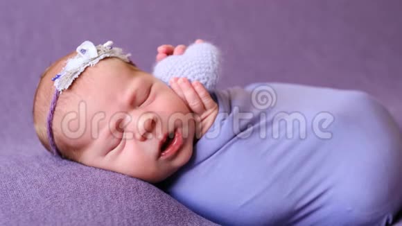 在紫罗兰毯上睡觉的新生儿视频的预览图