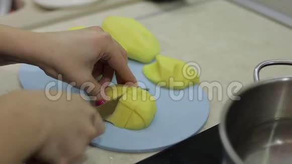 女人在蓝色砧板上切土豆视频的预览图