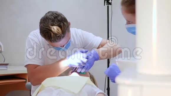 戴手套戴口罩的医务人员用现代仪器牙科医生办公室治疗牙齿视频的预览图